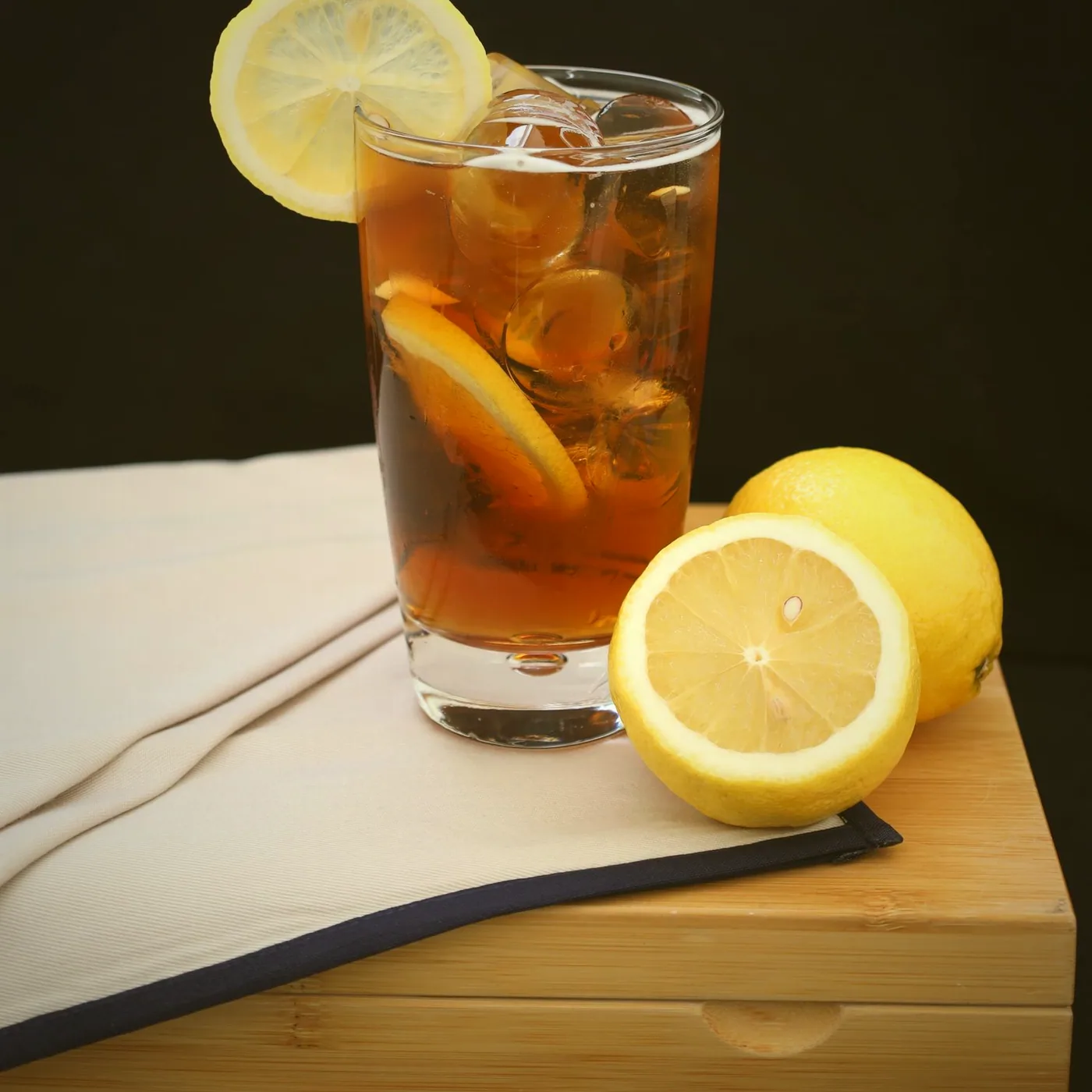 A glass of iced tea, lemon wheel and all